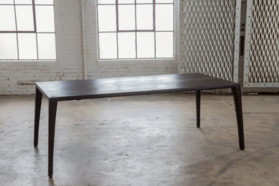 cherry finish dining table in empty warehouse room
