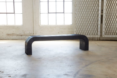black wood bench sitting in an open room