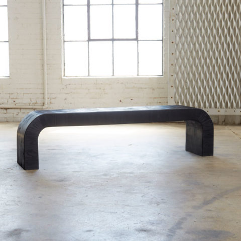 black wood bench sitting in an open room